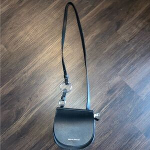 Melie Bianco women’s Black Crossbody Saddle Bag with Silver Ring Detail